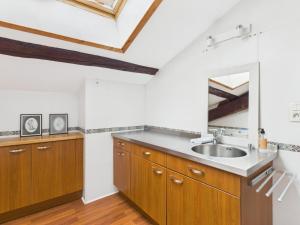 a kitchen with wooden cabinets and a sink at Séjourner au Château de la Roue Grand appartement in Lissieu +27 photos