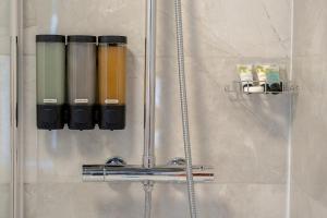 een groep flessen aan een muur in een douche bij Varley Terrace in Colne