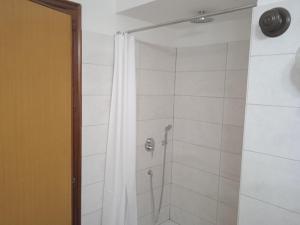 een douche met een wit douchegordijn in een badkamer bij appartamento Gabry in Dolianova +8 foto's
