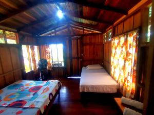 a bedroom with two beds in a room with windows at Cabinas Cocalitos in Rincón