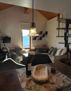 een woonkamer met een tafel met een fles wijn bij Rustico Guidotti in Bellinzona +7 foto's