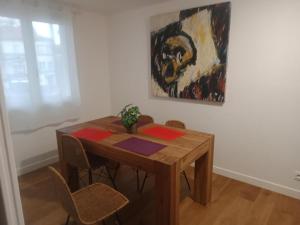 ein Esstisch mit Stühlen und ein Gemälde an der Wand in der Unterkunft TRINQUAT Gare Saint Roch in Montpellier
