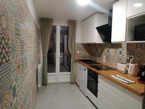 eine Küche mit weißen Schränken und einer gefliesten Wand in der Unterkunft TRINQUAT Gare Saint Roch in Montpellier + 9 Fotos