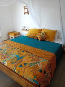 ein Schlafzimmer mit einem Bett mit einer Bettdecke und Kissen in der Unterkunft Studio vue mer avec cuisine et SDB in Capesterre + 14 Fotos