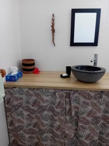 ein Badezimmer mit einem Waschbecken auf einer Holzablage in der Unterkunft Studio vue mer avec cuisine et SDB in Capesterre