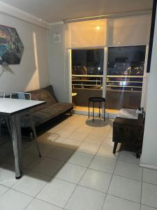 a living room with a couch and a large window at Departamento Puertas del Mar in La Serena +2 photos