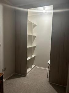 a closet with white shelves in a room at Departamento Puertas del Mar in La Serena
