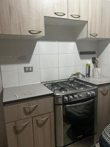 a kitchen with a stove top oven in a kitchen at Departamento Puertas del Mar in La Serena