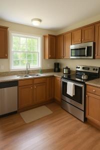 een keuken met houten kasten, een fornuis en een magnetron bij Private room with a private full bathroom in Woodbridge