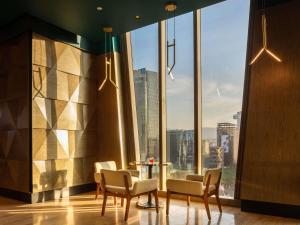 een kamer met stoelen en een tafel voor een groot raam bij Sofitel Mexico City Reforma in Mexico-Stad