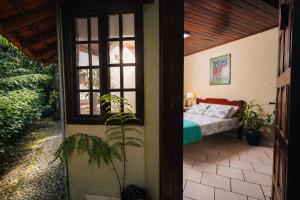 une chambre avec un lit et une fenêtre dans l'établissement Suíte Iberê - Pousada Jussara, à Joinville