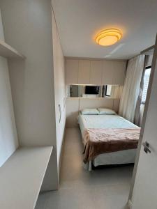 - une chambre avec un lit et une lumière jaune dans l'établissement Luxuoso Doce lar com Garagem, à Itapema
