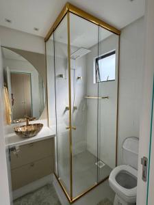 une salle de bain avec une douche en verre et des toilettes dans l'établissement Luxuoso Doce lar com Garagem, à Itapema 24 autres photos