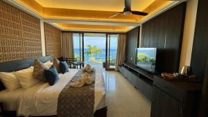 een kind op een bed in een hotelkamer bij The Point Resort Lembongan in Nusa Lembongan