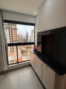 une cuisine avec une grande fenêtre offrant une vue sur la ville dans l'établissement Luxuoso Doce lar com Garagem, à Itapema
