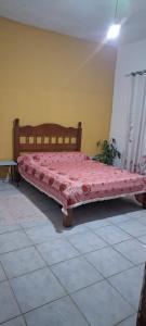 een bed met een rood dekbed in een kamer bij Pousada Renovo Beija-flor Espaço Terapêutico in Bertioga