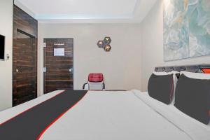 ein Schlafzimmer mit einem großen weißen Bett mit Stühlen in der Unterkunft Collection O Halcyon SS Grand in Hyderabad