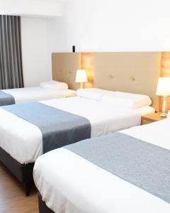 een hotelkamer met drie bedden en twee lampen bij Hostal Llampayec in Chiclayo +28 foto's