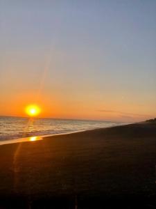 een zonsondergang op een strand met de oceaan bij Casa Doral Monterrico in Monterrico