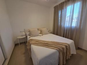 a bedroom with a large bed with a window at Oliva Home in Los Cristianos