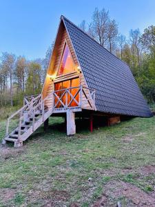 een klein huis met een dak op een veld bij Araucaria Lodge Cabaña Alpina cerca del Parque Conguillío in Curacautín