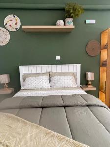 een slaapkamer met een groot bed met een groene muur bij Studio Sol e Sal in Santa Maria