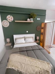 een slaapkamer met een groot bed met een groene muur bij Studio Sol e Sal in Santa Maria