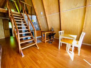 een kamer met een houten trap, een tafel en een bureau bij Araucaria Lodge Cabaña Alpina cerca del Parque Conguillío in Curacautín