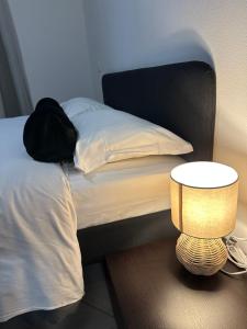 een bed met een zwart hoofdeinde en een tafel met een lamp bij SognaRE appartament in Reggio Emilia