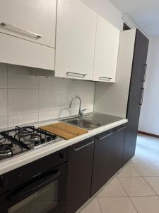 een keuken met een spoelbak en een fornuis bij SognaRE appartament in Reggio Emilia
