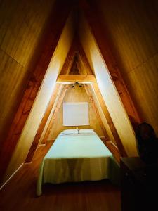 een kamer met een bed in het midden van een zolder bij Araucaria Lodge Cabaña Alpina cerca del Parque Conguillío in Curacautín