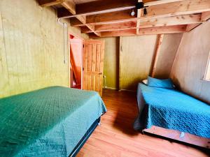 een slaapkamer met 2 bedden in een kleine kamer bij Araucaria Lodge Cabaña Alpina cerca del Parque Conguillío in Curacautín +13 foto's