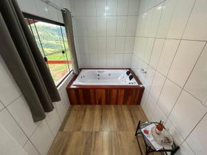 una vasca da bagno in una stanza con una finestra di Oasis na montanha a Bueno Brandão Altre 20 foto