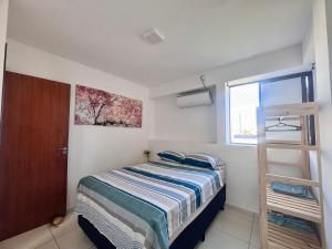 a small bedroom with a bed and a window at Apê aconchegante perto do mar in Cabedelo