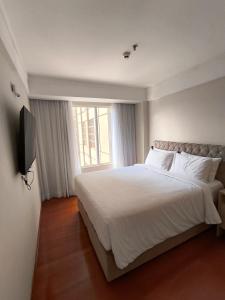 ein Schlafzimmer mit einem großen Bett und einem Fenster in der Unterkunft GRU Airport Easy Stay in Guarulhos