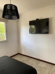 a bedroom with a flat screen tv on the wall at Duplex del Parque y Balneario in Necochea