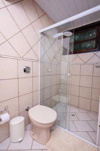 une salle de bains avec toilettes et douche en verre dans l'établissement Suíte Iberê - Pousada Jussara, à Joinville 25 autres photos