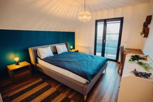 ein Schlafzimmer mit einem Bett und einer blauen Wand in der Unterkunft Cabana NorthSpot in Horodnic de Sus