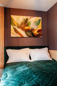 a bedroom with a bed with two paintings on the wall at Sky Lux Cozy Nest in Jahorina