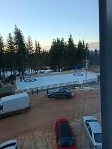 a parking lot with cars parked in front of a building at Sky Lux Cozy Nest in Jahorina