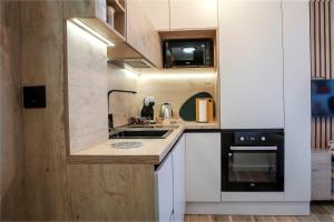 a small kitchen with a sink and a stove at Sky Lux Cozy Nest in Jahorina +9 photos