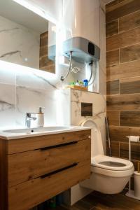 a bathroom with a toilet and a sink with a light at Sky Lux Cozy Nest in Jahorina