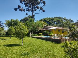 een huis met een zwembad in een tuin bij Chacara do japonês 