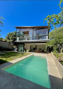 a house with a swimming pool in front of a house at Jungle surf Villa in El Zonte