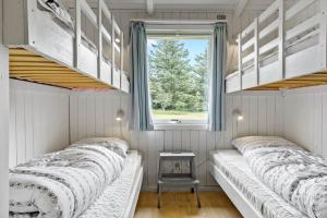 twee bedden in een kleine kamer met een raam bij 421-Thisted-Fiskervej-147 in Nørre Vorupør
