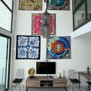 a living room with art on the walls at Hermes Penthouse Sea Sky & Mountains in Akanthou