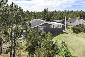 una piccola casa nera in mezzo a un cortile di 682-Thisted-Klitrosevej-66 a Thisted