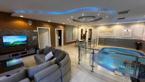 a living room with a tv and a swimming pool at شاليه ايلان المدينة المنورة in Medina