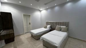 a bedroom with two beds and a piano at شاليه ايلان المدينة المنورة in Medina +9 photos