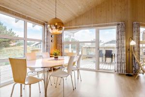 een eetkamer met een tafel en stoelen en een balkon bij 990-Thisted-Spanggardsvej-29 in Torsted